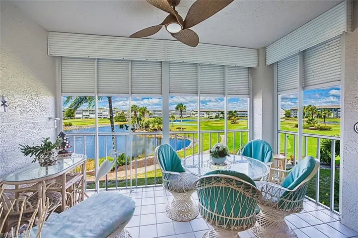 Sunroom with a textured wall, tile patterned flooring, a textured ceiling, and a water view