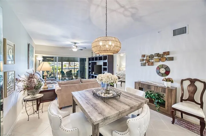 Dining area with ceiling fan, suspended lighting, and light tile patterned floors