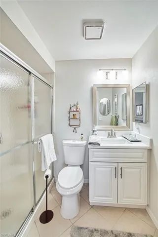 Full bathroom featuring vanity, a stall shower, and light tile patterned floors