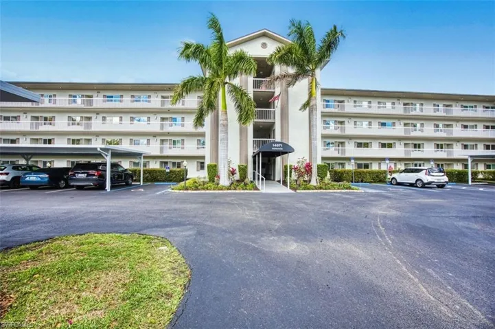 View of apartment building / complex with uncovered parking