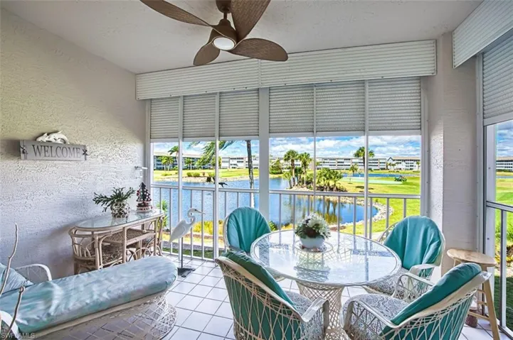 Sunroom featuring outdoor dining space, a ceiling fan, and a balcony