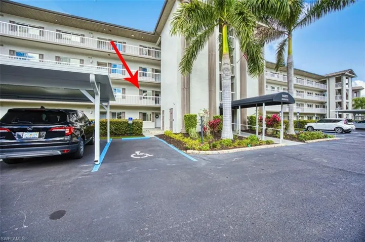 View of apartment building / complex with covered parking