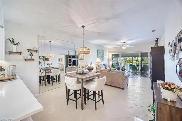 Dining room with light tile patterned floors, ceiling fan, and hanging lights
