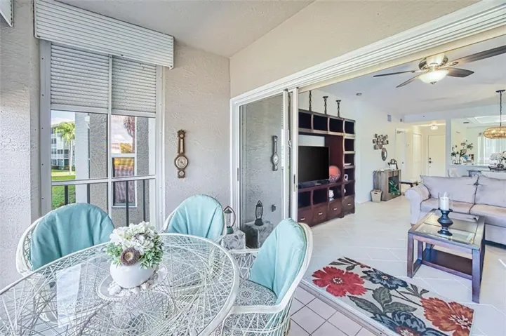 Dining area featuring a textured wall, a ceiling fan, and light tile patterned floors