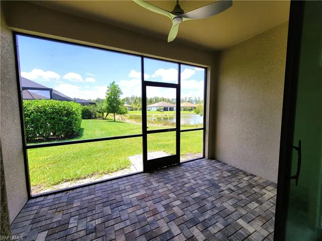 Unfurnished sunroom featuring ceiling fan and a water view
