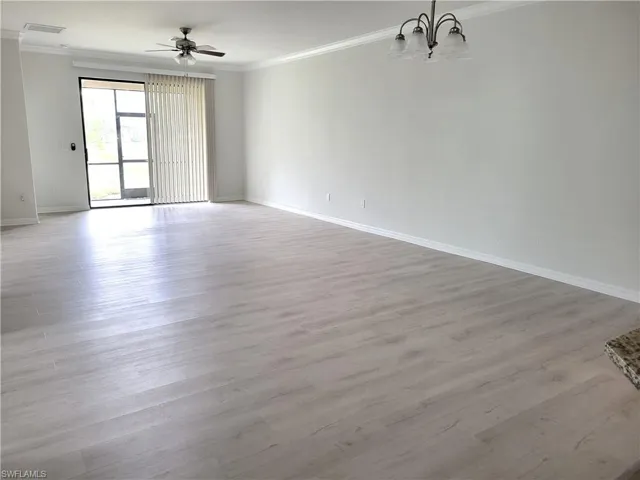 Unfurnished room featuring ornamental molding, light wood-style floors, a ceiling fan, and hanging lights