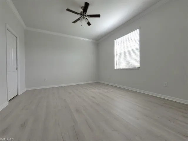 Unfurnished bedroom with a ceiling fan, light wood-type flooring, and ornamental molding