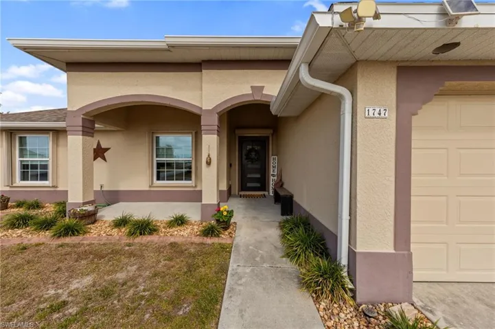Doorway to property featuring stucco siding and a porch
