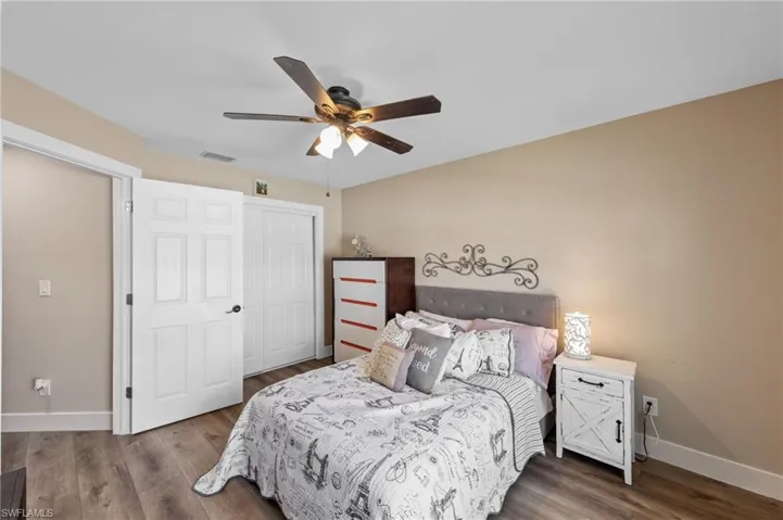 Bedroom with wood finished floors, a ceiling fan, and a closet