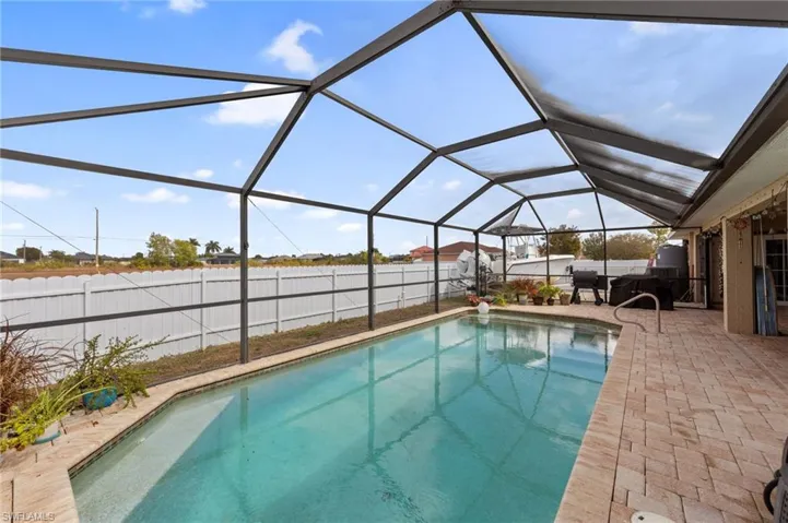 View of swimming pool with a sunroom, a lanai, a fenced backyard, and patio surround