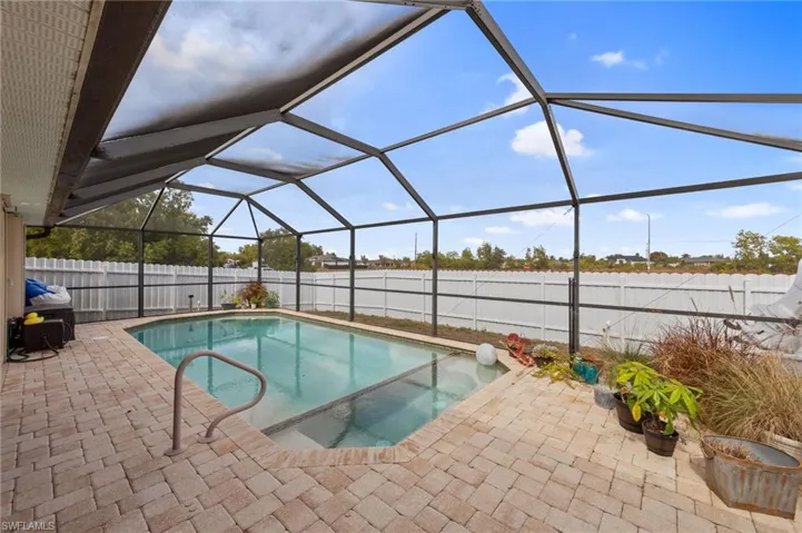 View of pool with a fenced backyard, a sunroom, a lanai, and patio surround