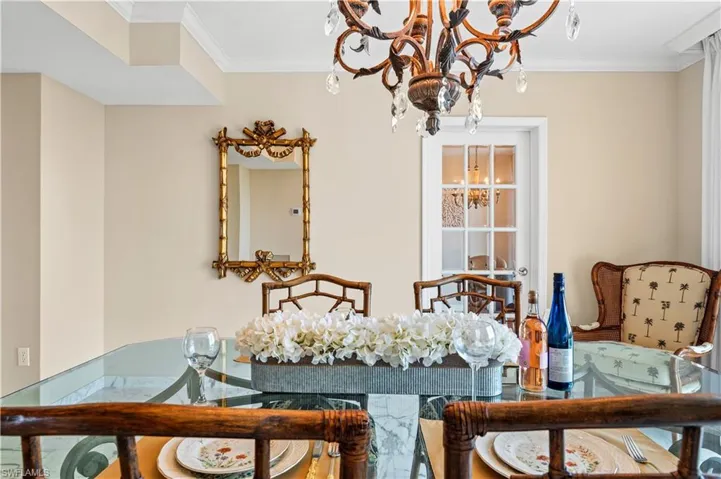 Dining space with ornamental molding and a chandelier