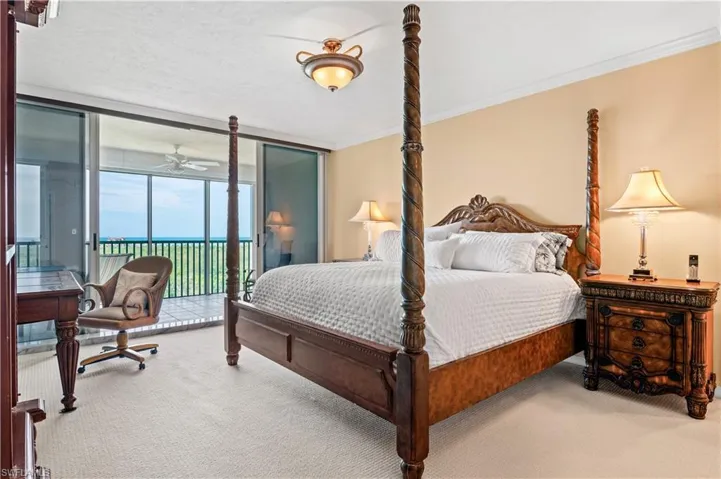 Carpeted bedroom featuring a wall of windows, crown molding, access to exterior, and a water view