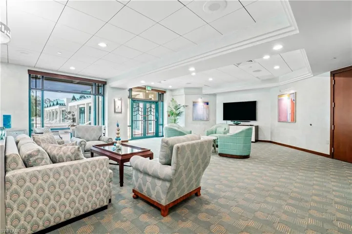 Carpeted common area with recessed lighting and french doors that open to the community pool