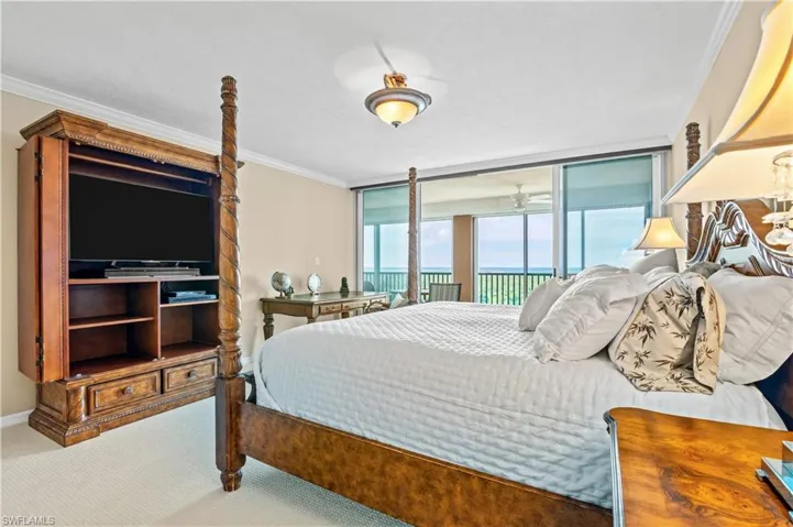 Bedroom with ornamental molding, carpet, access to outside, expansive windows, and a water view