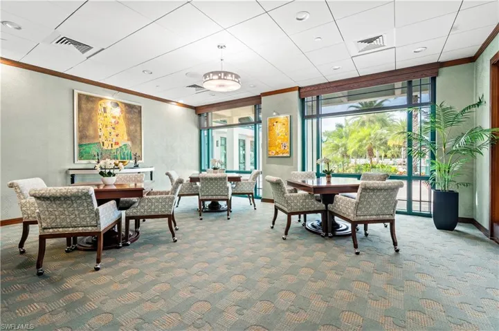 Building lobby game room with crown molding and a wall of windows looking out to the community pool