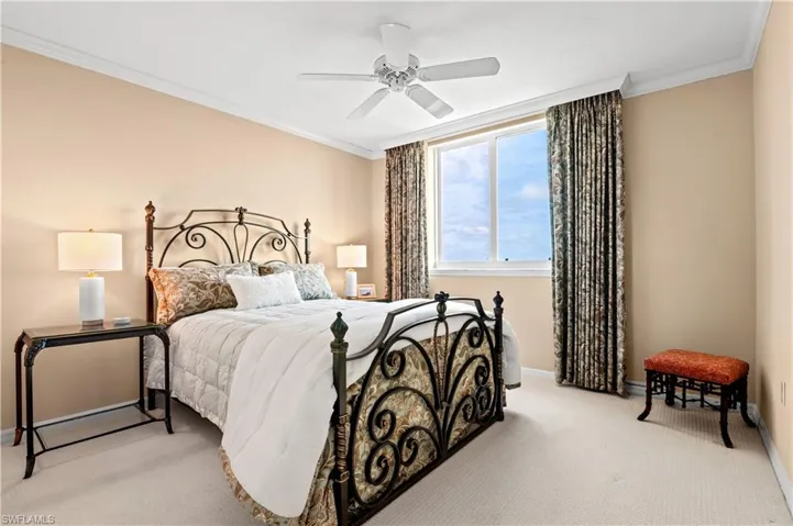 Carpeted bedroom featuring crown molding and ceiling fan