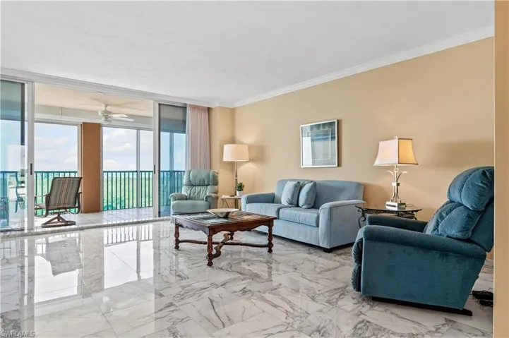 Living area with floor to ceiling windows, marble tiled floors, crown molding, and a ceiling fan