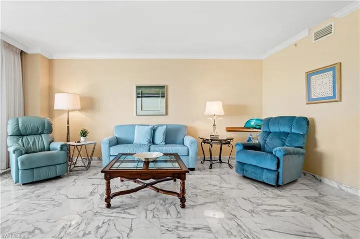 Living room with crown molding and marble look tiles