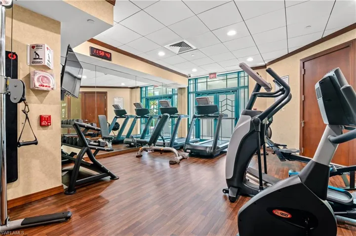 Exercise room featuring a drop ceiling and expansive windows