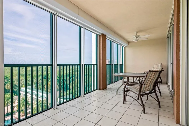Screened balcony featuring tile patterned floors with views of the Gulf