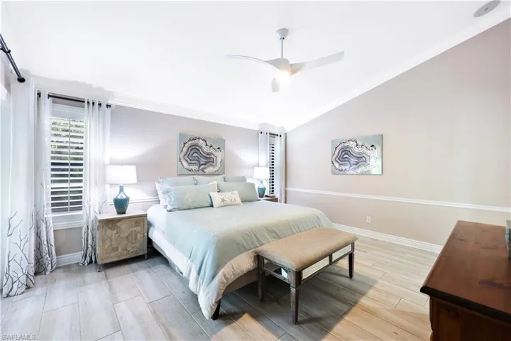 Bedroom with ceiling fan, ornamental molding, and vaulted ceiling