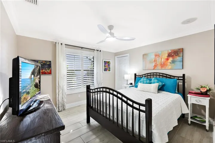 Bedroom with ceiling fan and crown molding