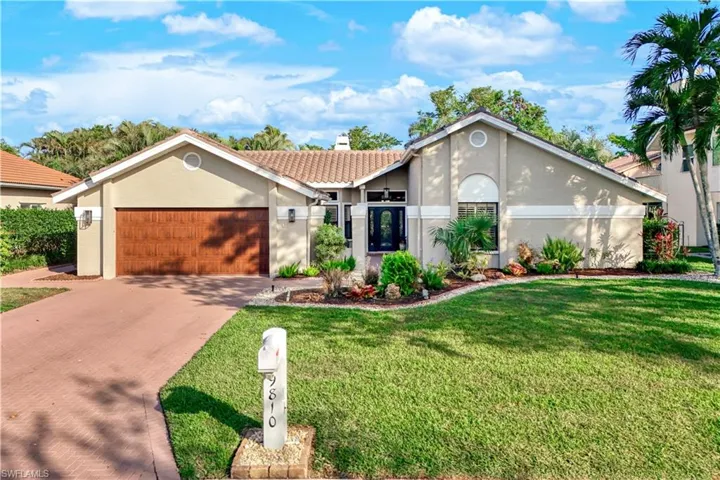 Ranch-style home featuring a garage and a front lawn