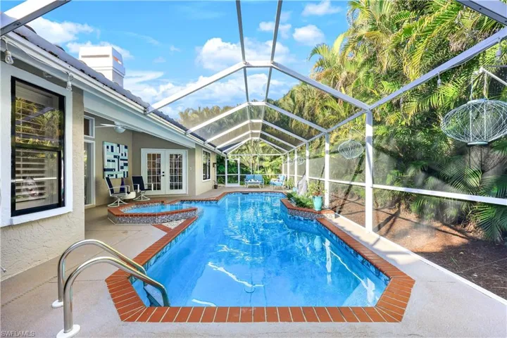View of pool featuring french doors, a patio, glass enclosure, and ceiling fan