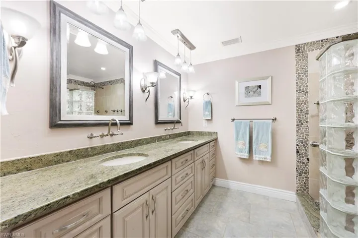 Bathroom featuring vanity, walk in shower, and ornamental molding