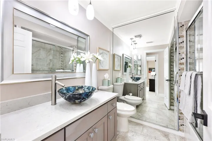 Bathroom with vanity, a bidet, toilet, ornamental molding, and an enclosed shower