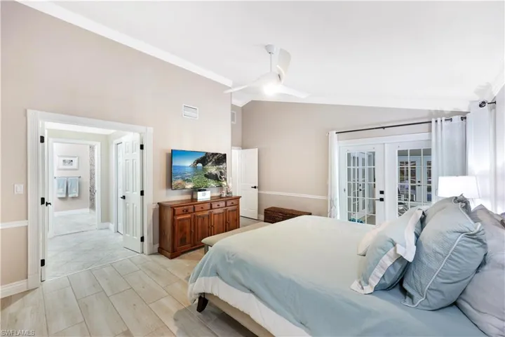 Bedroom with access to exterior, french doors, ornamental molding, ceiling fan, and lofted ceiling