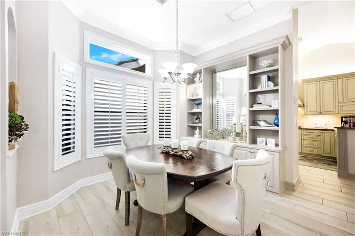 Dining room with crown molding, a chandelier, and light wood-type flooring