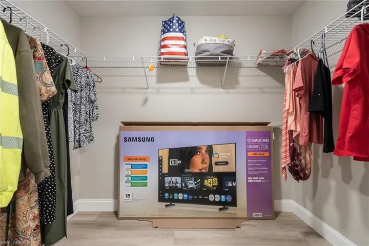 Closet with wire shelving, hanging rods, and wood-finish flooring
