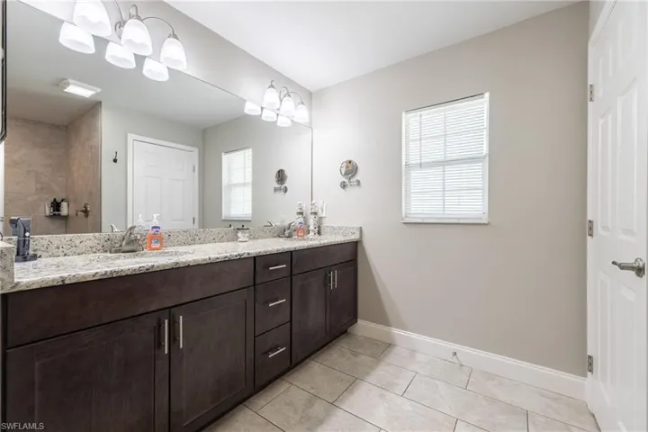 Double vanity with a granite countertop and wood-finish cabinetry