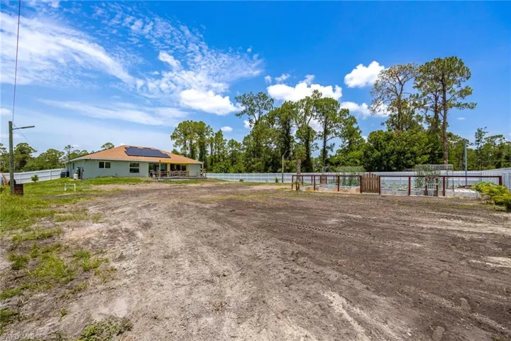 Expansive property with a fenced perimeter and a structure featuring solar panels
