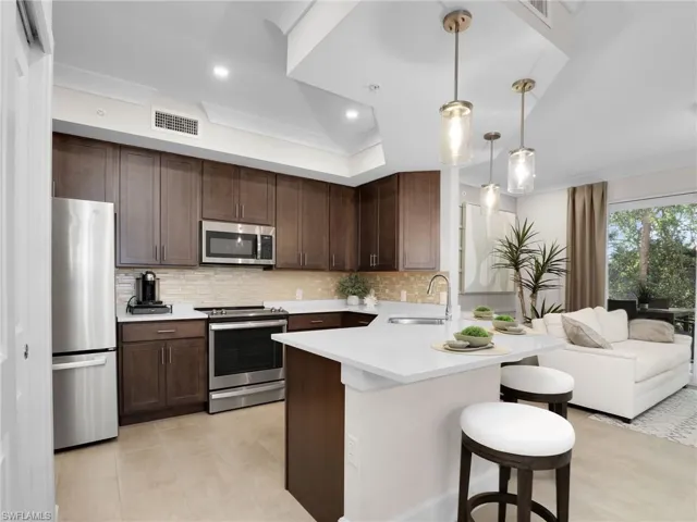 Kitchen with sink, hanging light fixtures, stainless steel appliances, a kitchen breakfast bar, and kitchen peninsula