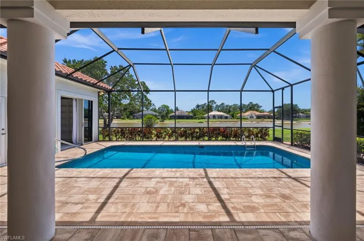 Relaxing pool area framed by lush landscaping and wide water vistas