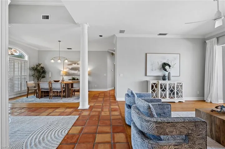 Open-concept living and dining spaces with volume ceilings and architectural columns