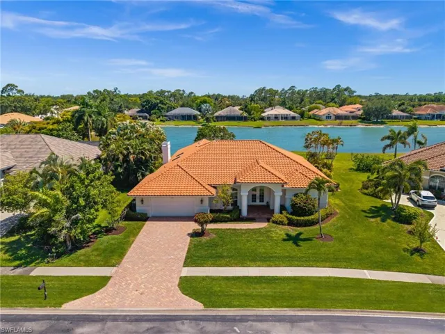 Beautifully maintained lakefront residence with wide water views and lush tropical landscaping