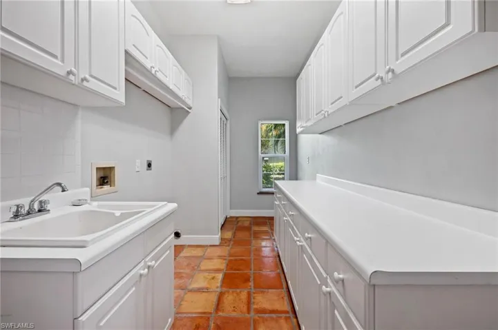 Dedicated laundry room with built-in cabinetry and ample storage