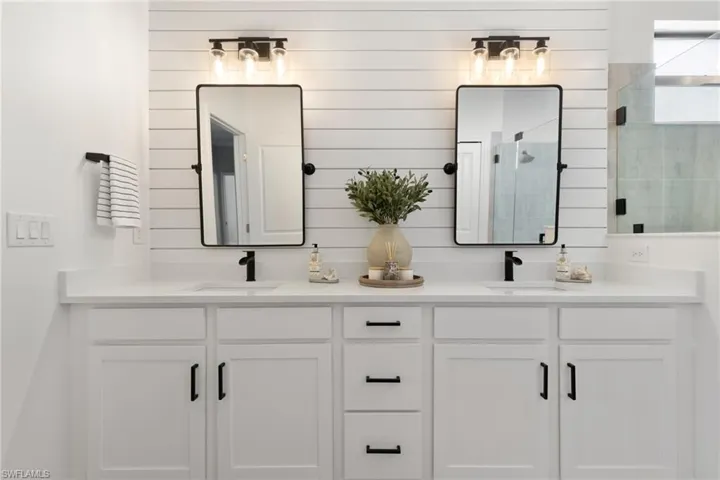Bathroom with dual vanity and a shower with door
