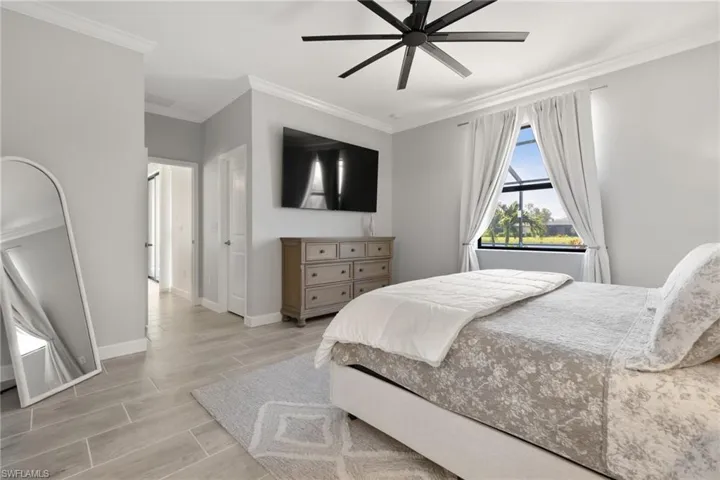 Bedroom with ceiling fan and crown molding