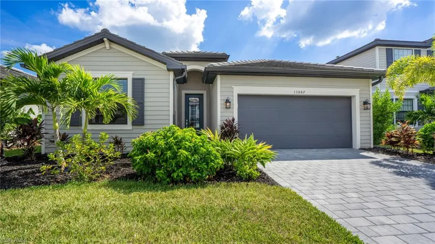 View of front facade featuring a front lawn and a garage