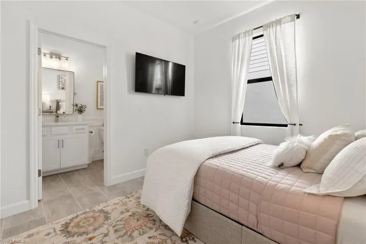 Bedroom with light tile patterned flooring and ensuite bathroom
