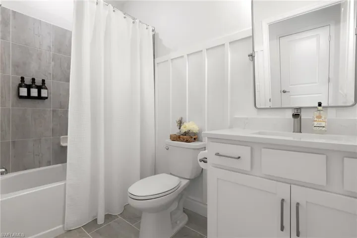 Full bathroom featuring tile patterned flooring, vanity, shower / tub combo with curtain, and toilet