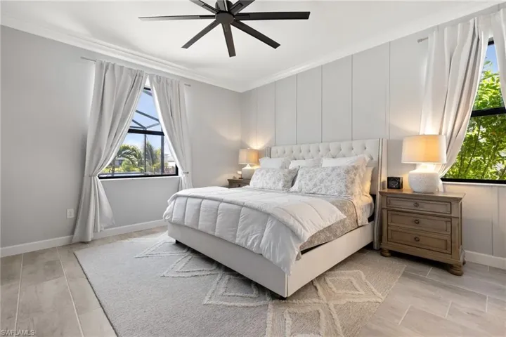 Bedroom featuring multiple windows, crown molding, and ceiling fan