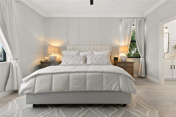 Bedroom with ceiling fan, crown molding, and ensuite bathroom