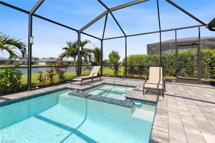 View of pool featuring an in ground hot tub, a patio area, and a lanai