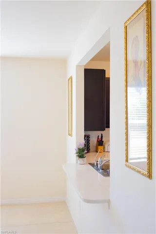 Corridor with baseboards and light tile patterned floors